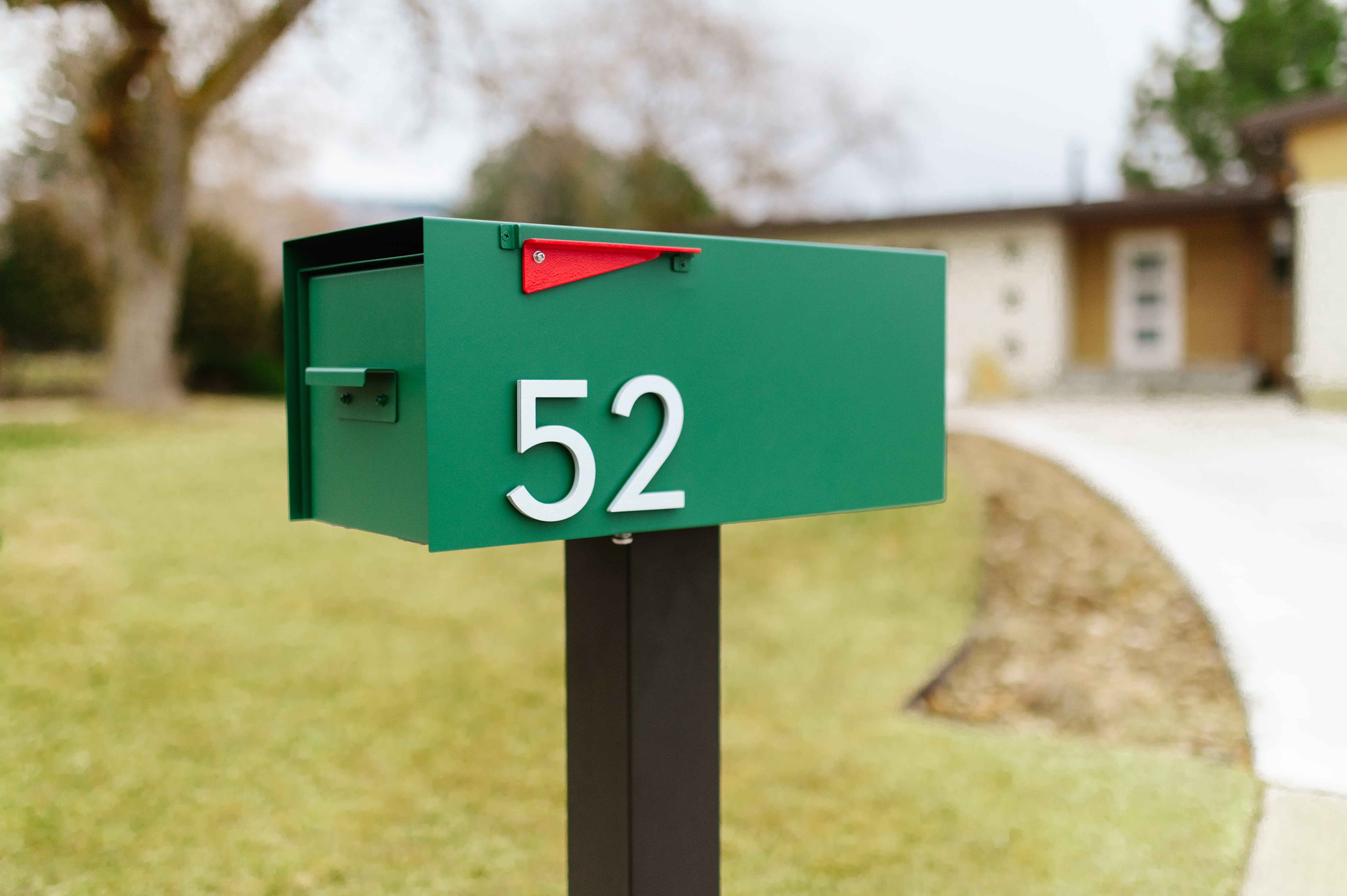 Green mailbox with black mailbox post; Post & Porch's The Malone Modern Mailbox for boosted curb appeal