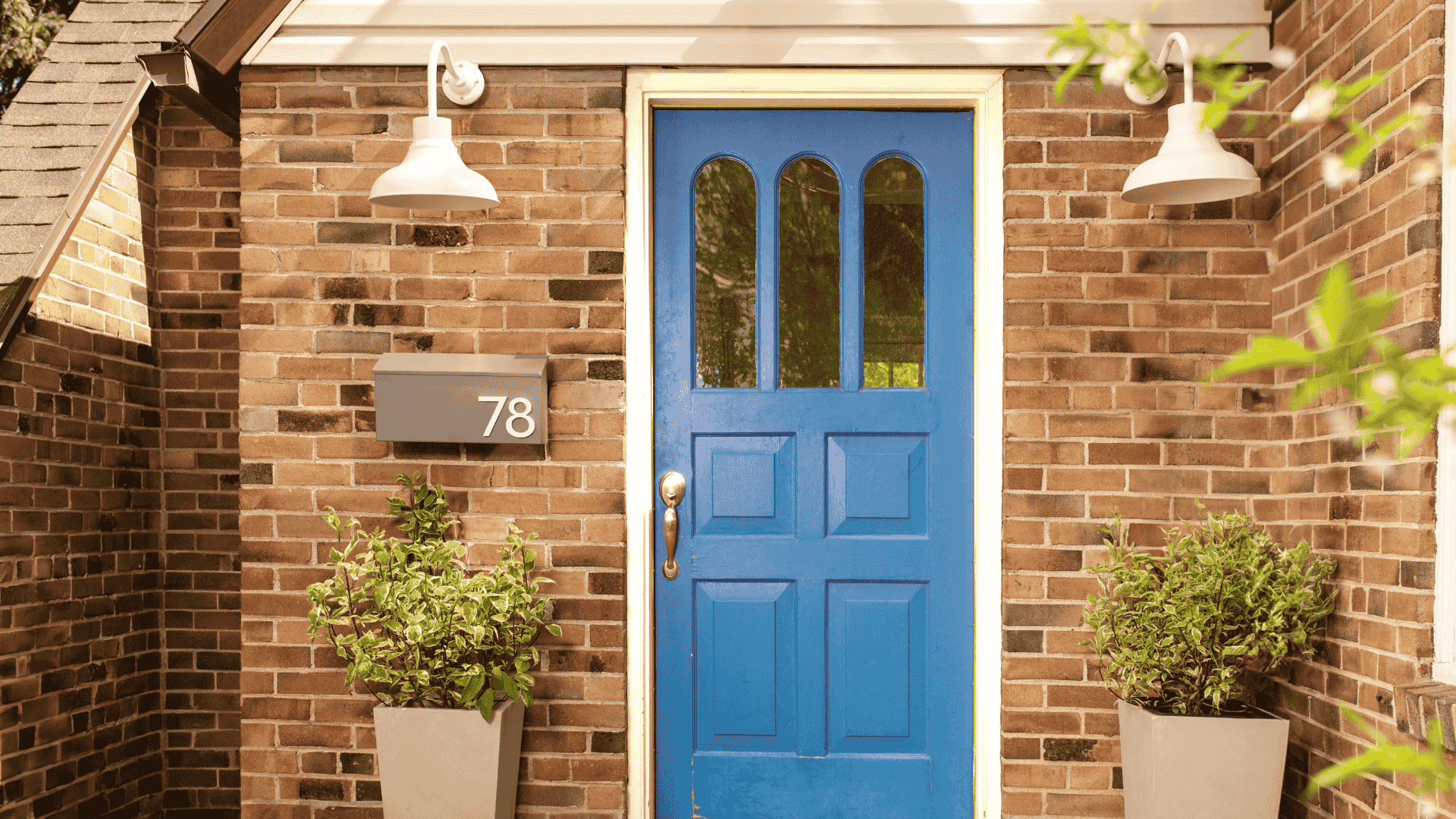 Home with great curb appeal; curb appeal enhancements by Post & Porch, including outdoor wall lighting, wall-mount mailboxes, and front porch planter pots