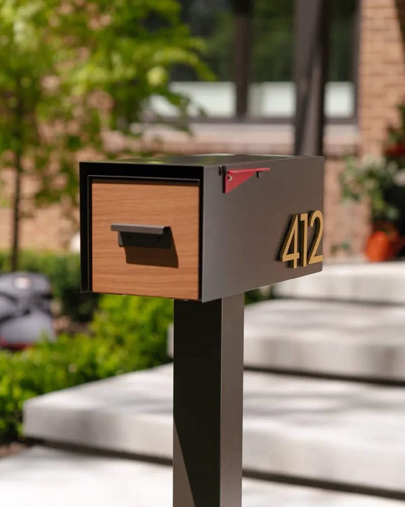 The Malone with a wood door and brass house numbers 412 in front of a brick home